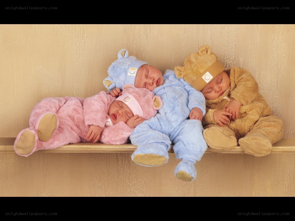 Three babies sleeping in bear suits
