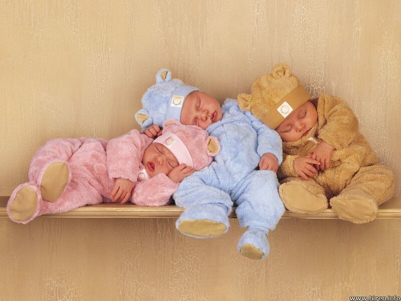 three babies sleeping on a shelf