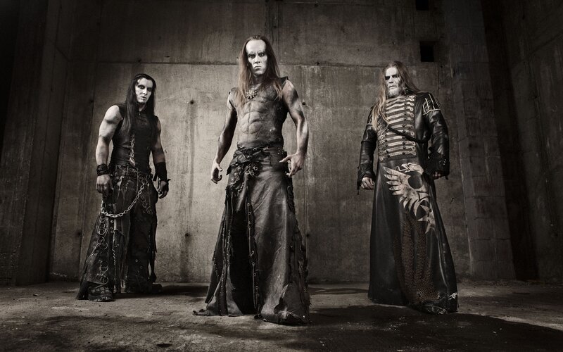 three band members in dark attire