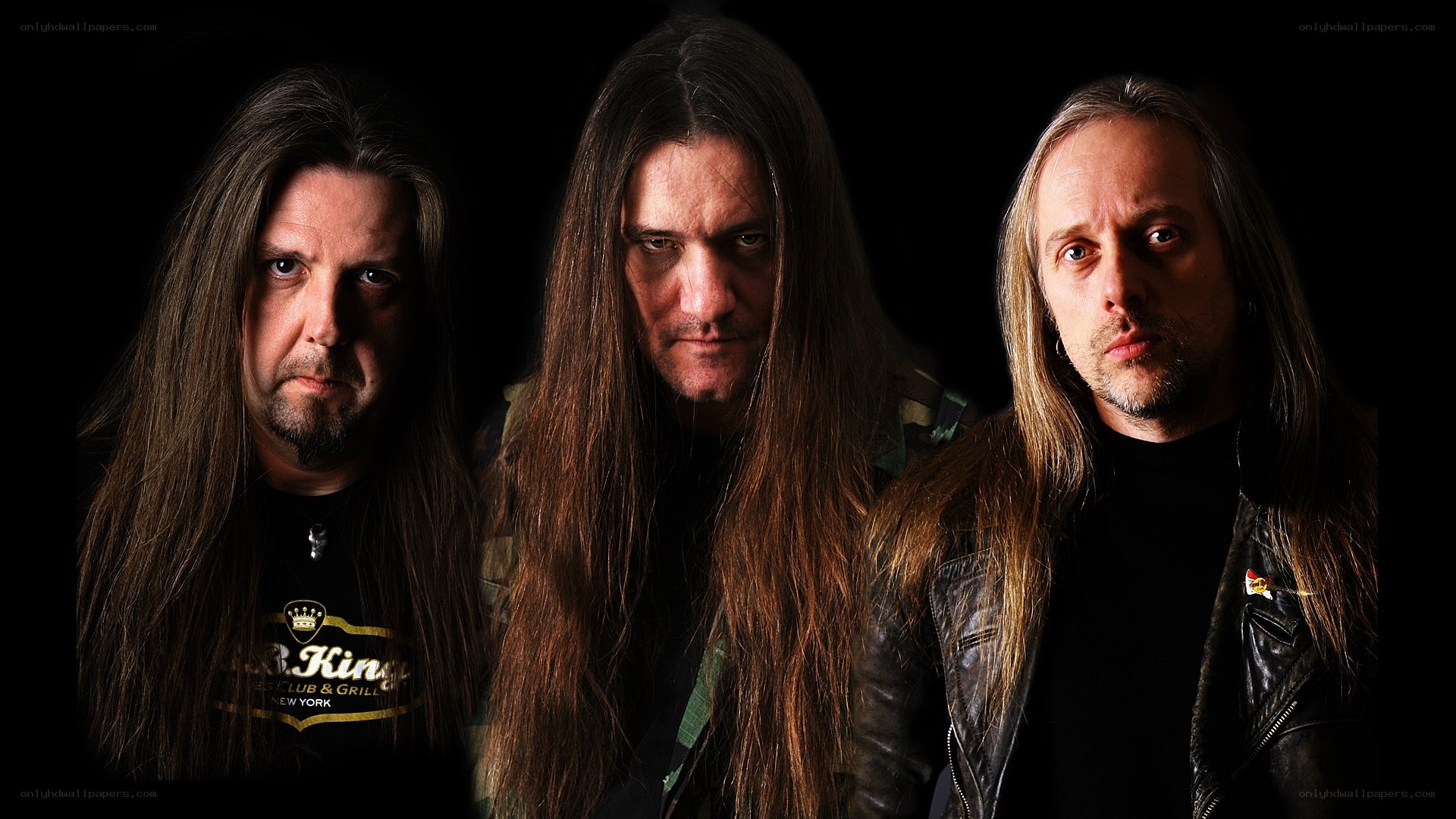 three band members in dark setting