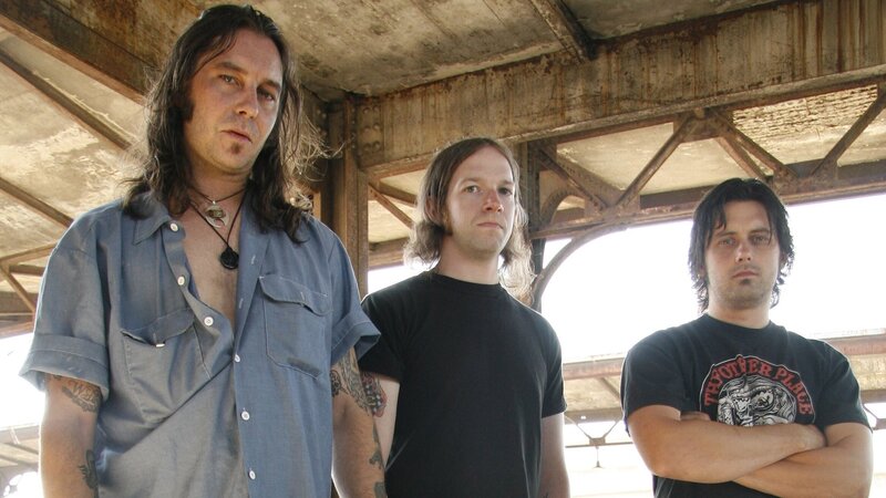 three band members standing