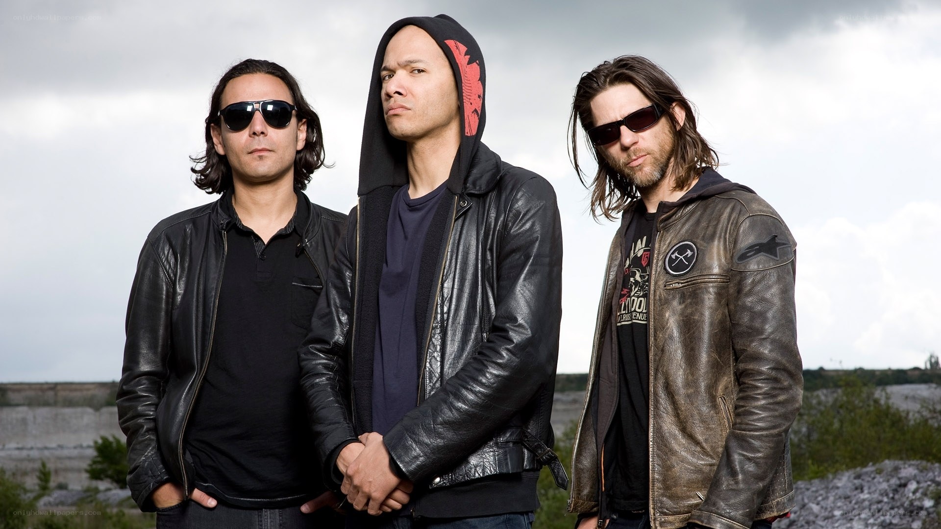 three band members standing together