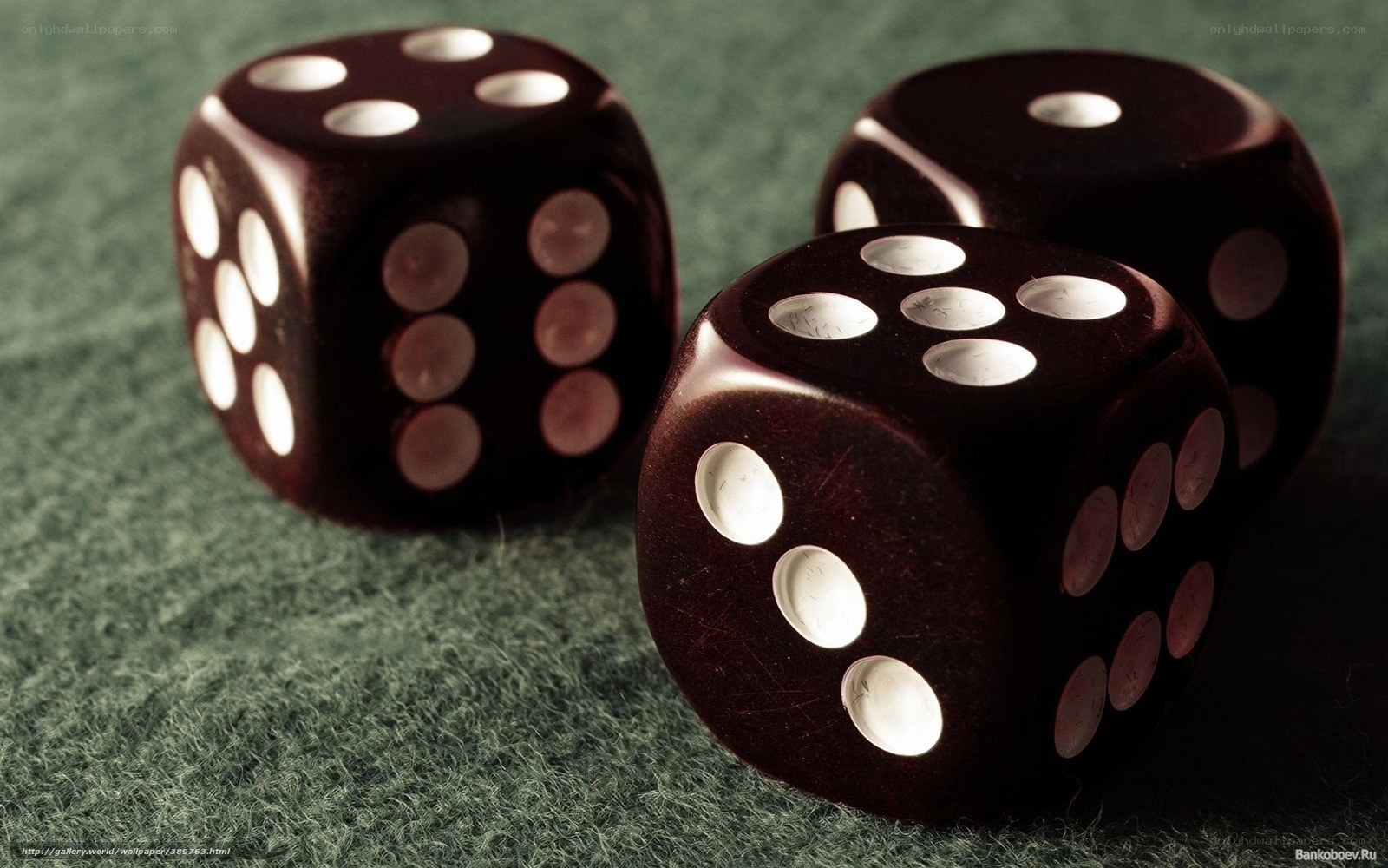 Three black dice on green felt