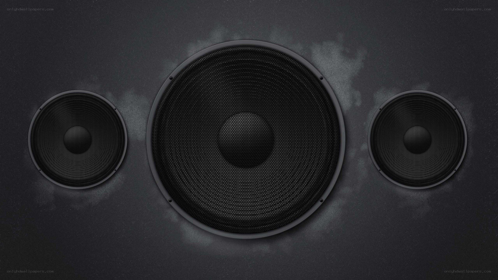 three black speakers on dark surface