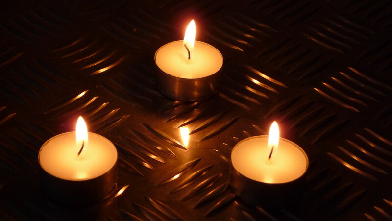 Three candles on metal surface