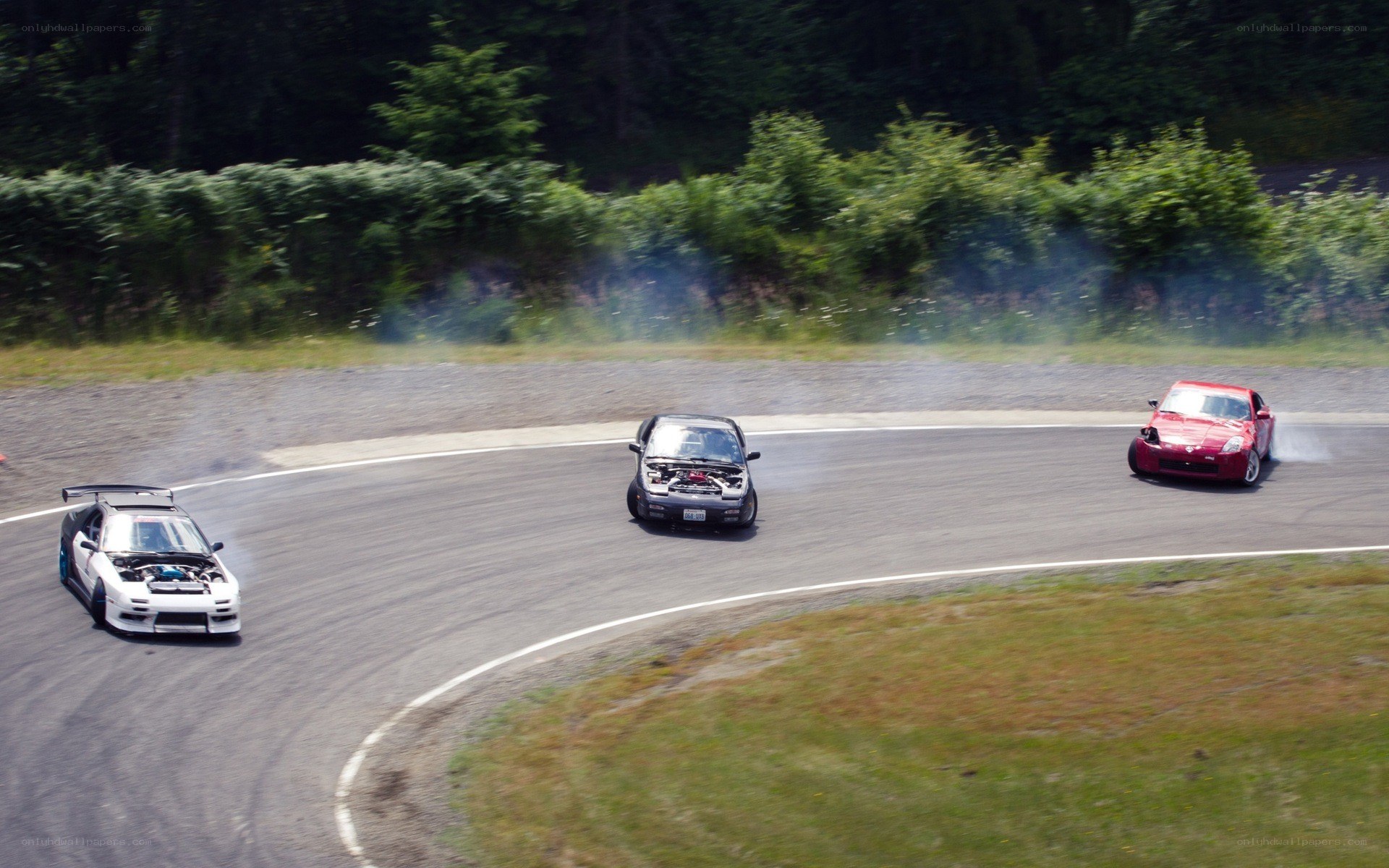 Three cars drifting on a track