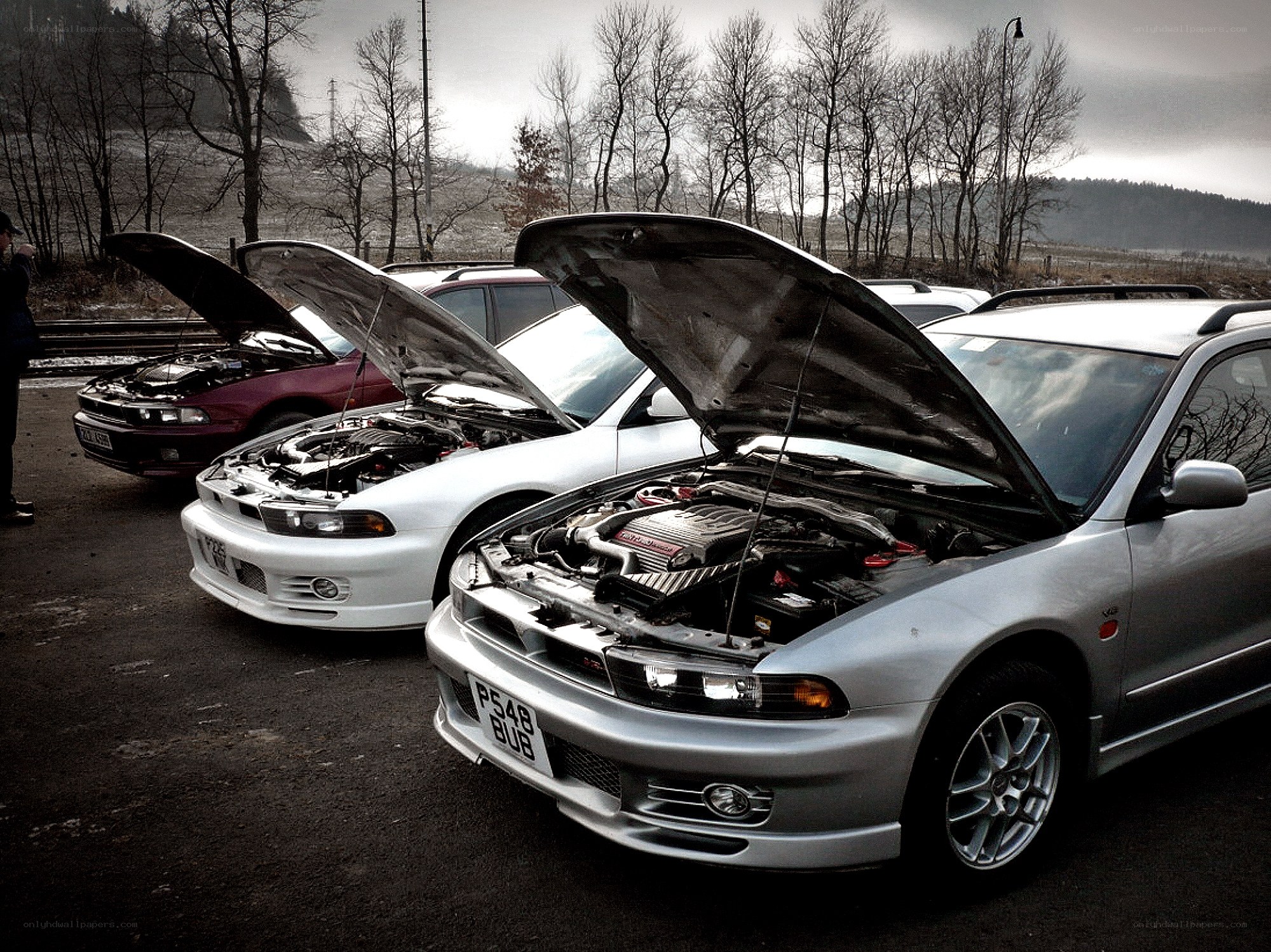 three cars with open hoods