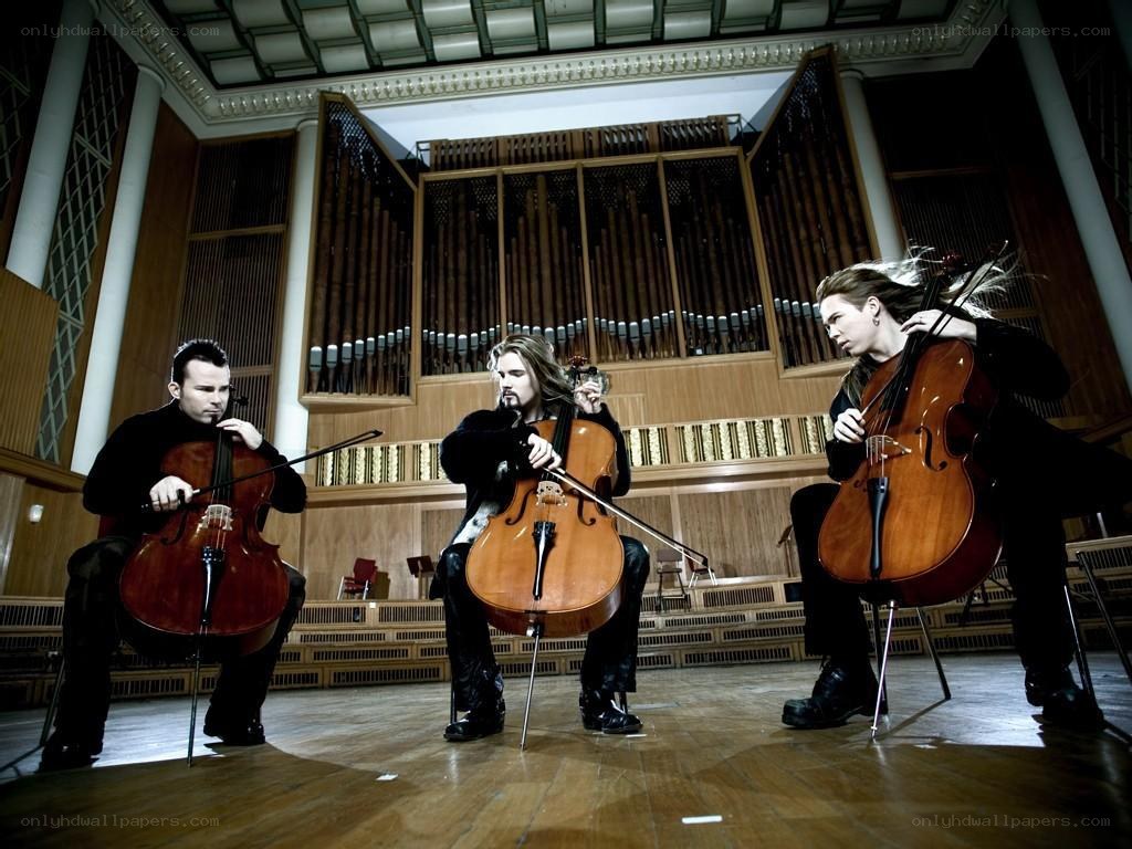 Three cellists performing in a concert hall