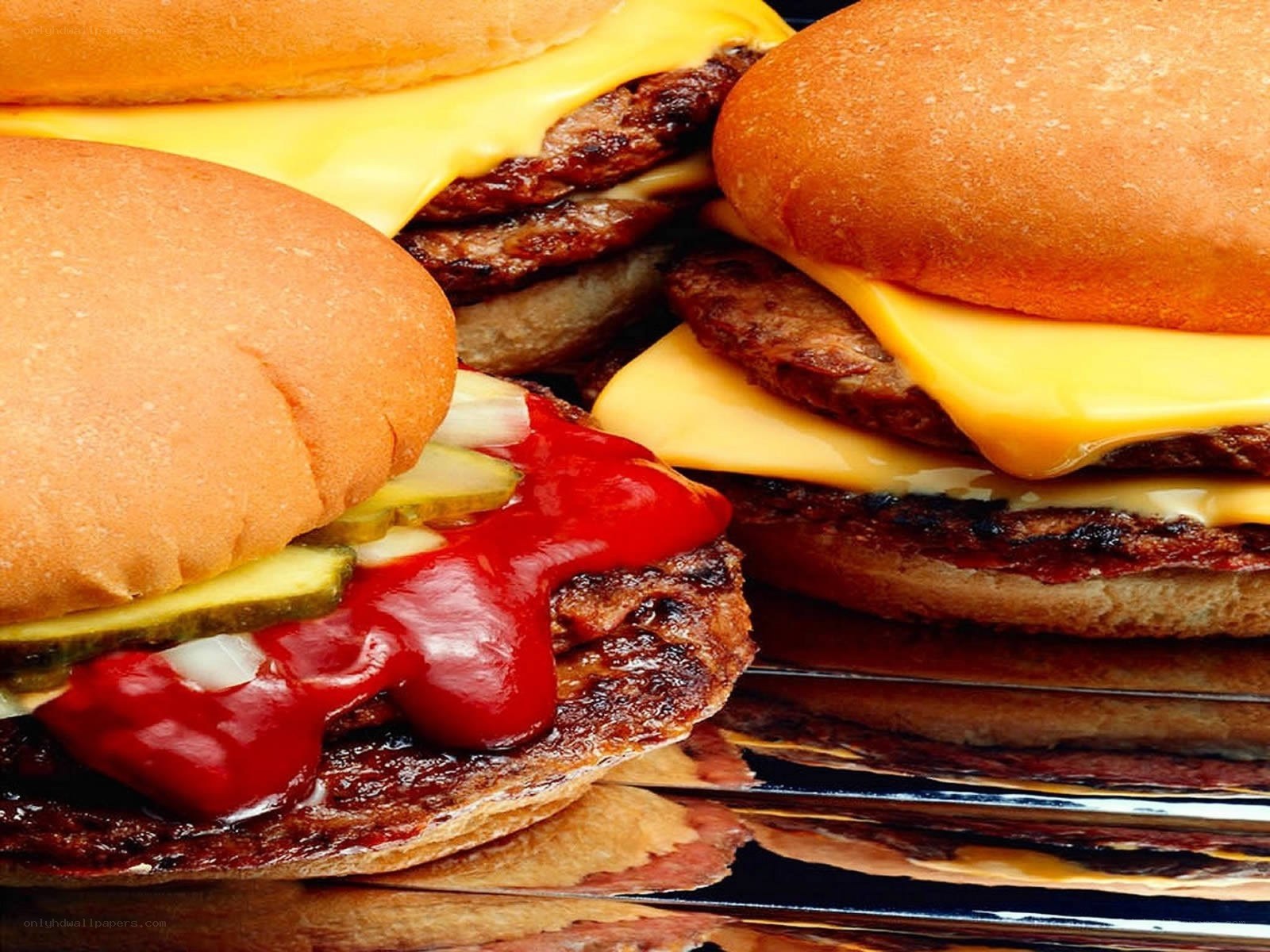 Three cheeseburgers on a grill