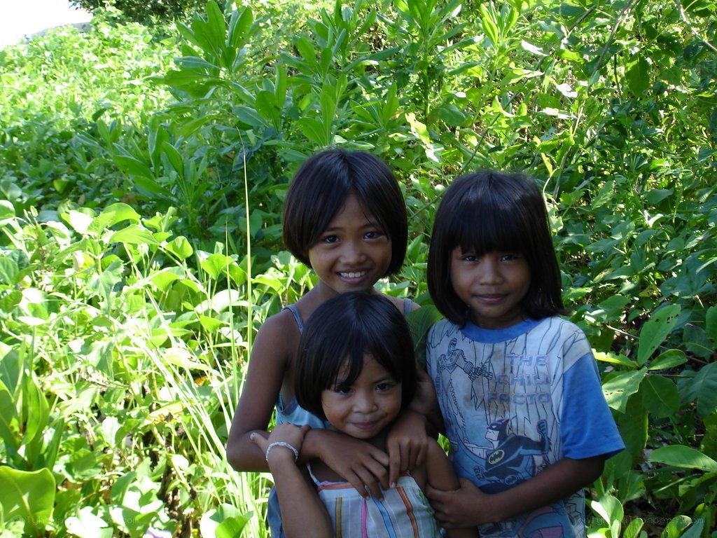 three children in green foliage