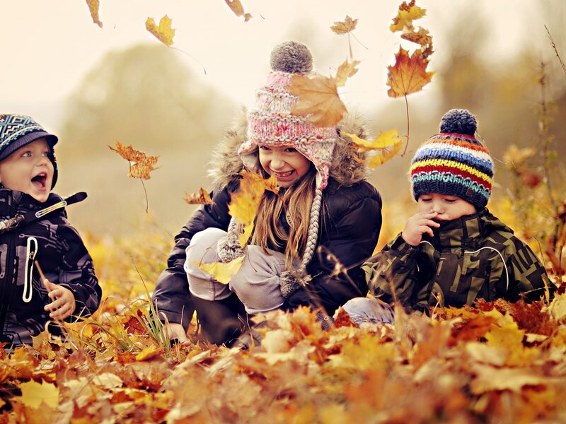 Three Children in Leaves — Yellow, Playful