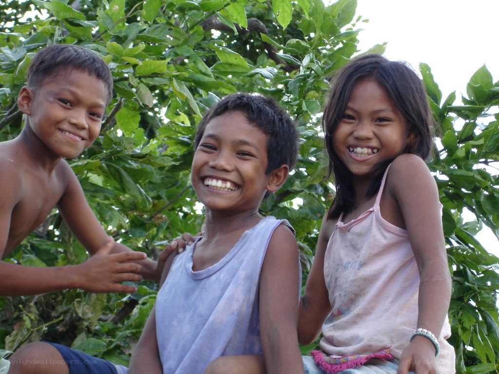 three children smiling outdoors
