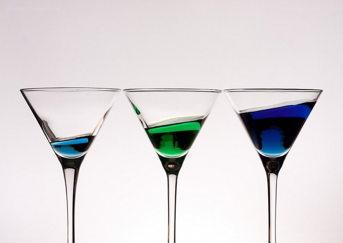 Three cocktail glasses with colored liquids
