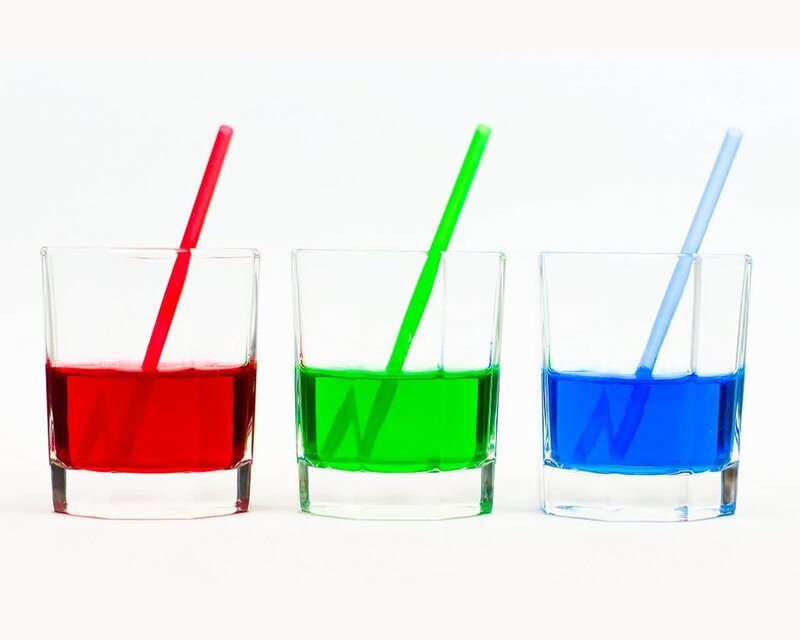 three colored drinks with straws