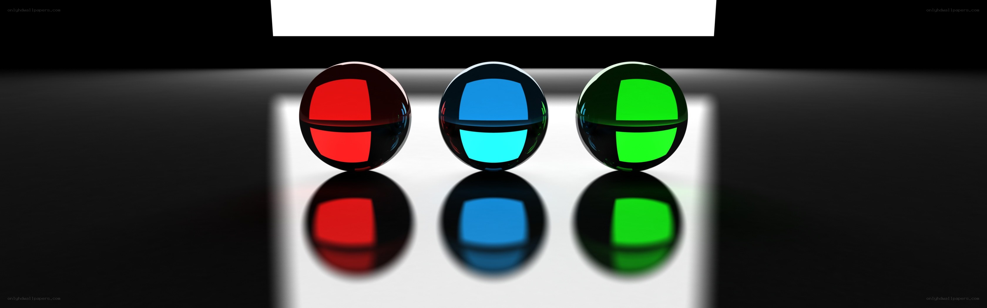 Three colored spheres on reflective surface