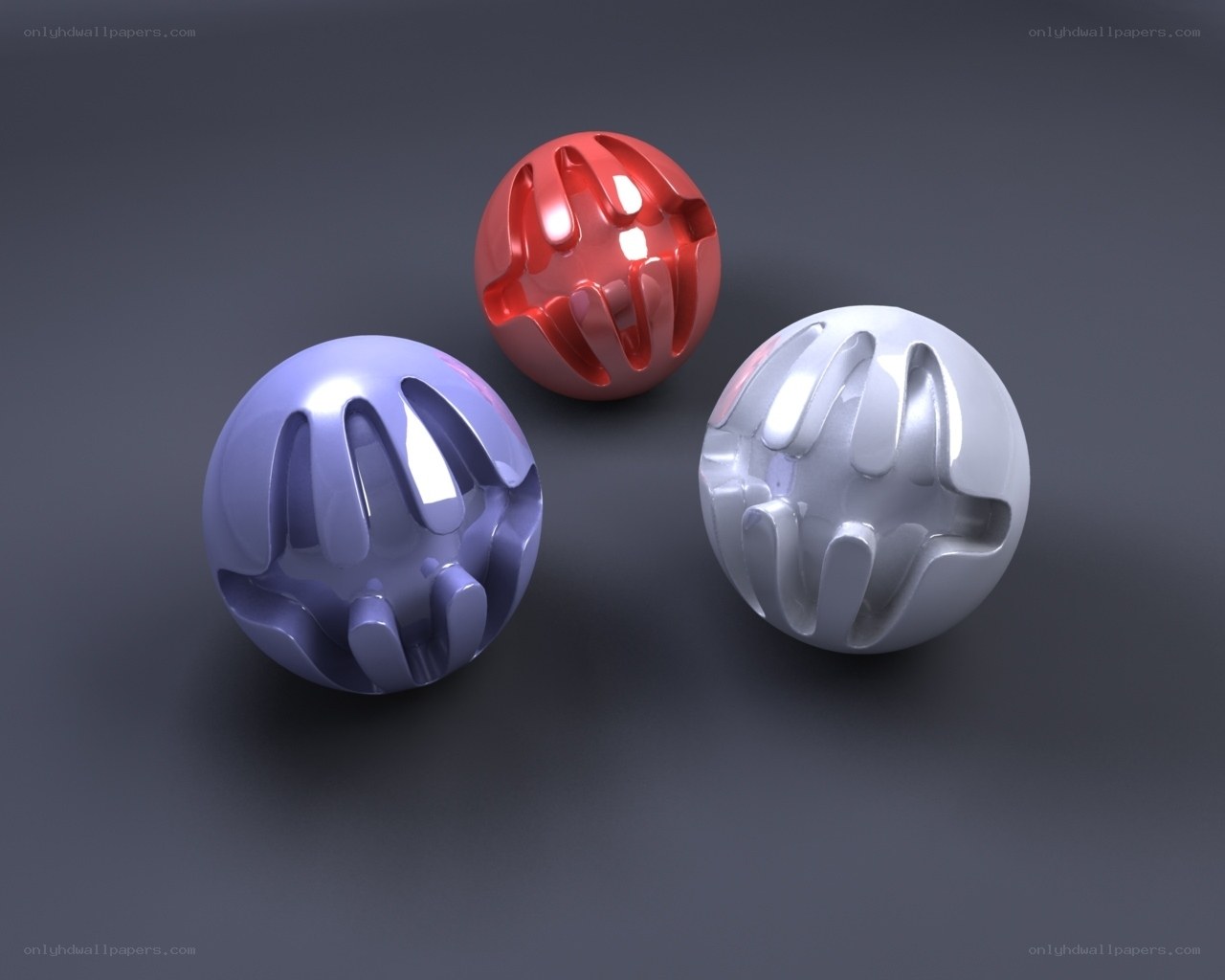 Three colored spheres with hand impressions