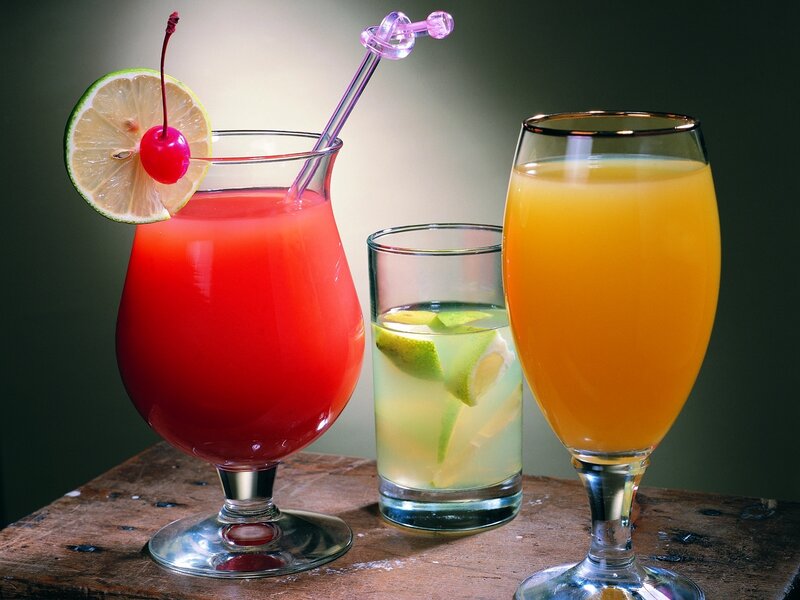 Three colorful cocktails on wood