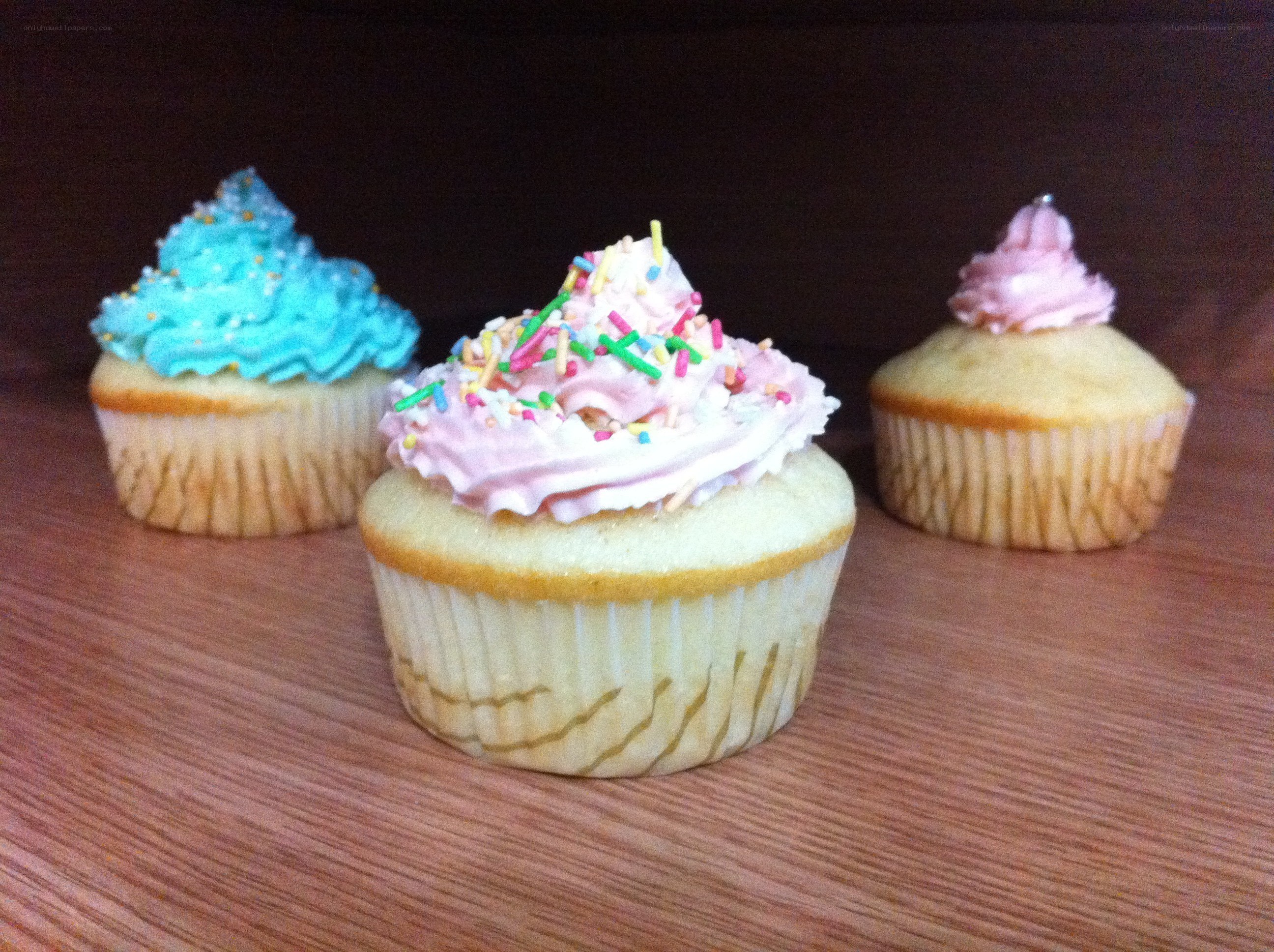 Three colorful cupcakes on a table