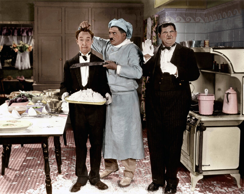 Three comedians in a kitchen