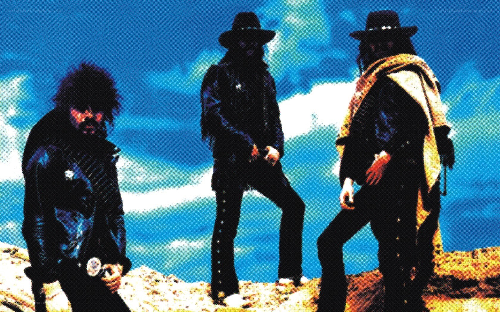 three cowboys on a hill