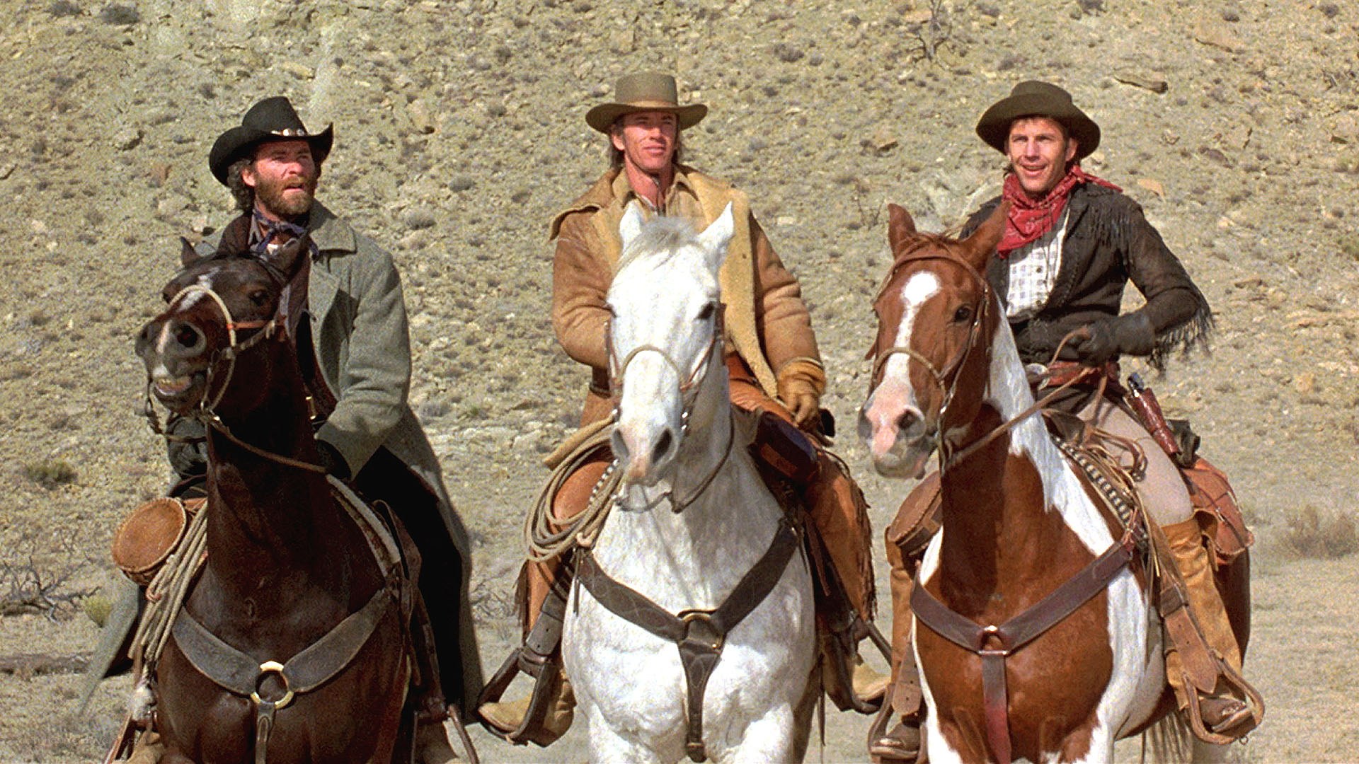 three cowboys on horseback