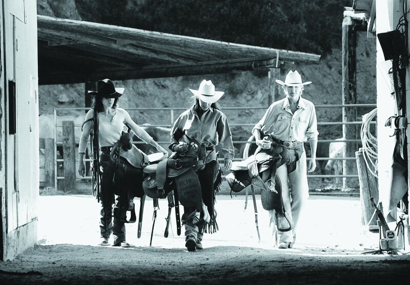 Three Cowgirls with Saddles
