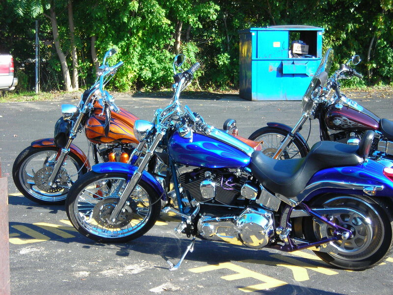 Three custom motorcycles parked