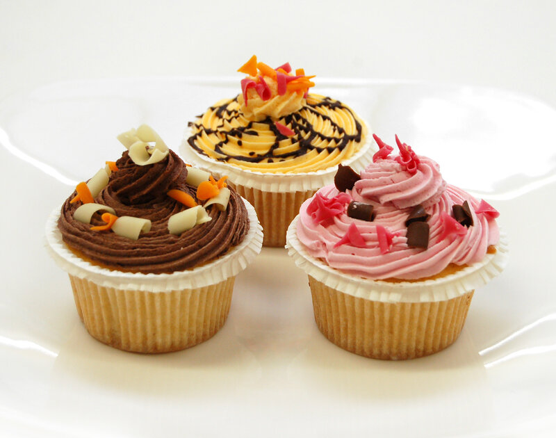 Three decorated cupcakes on a plate