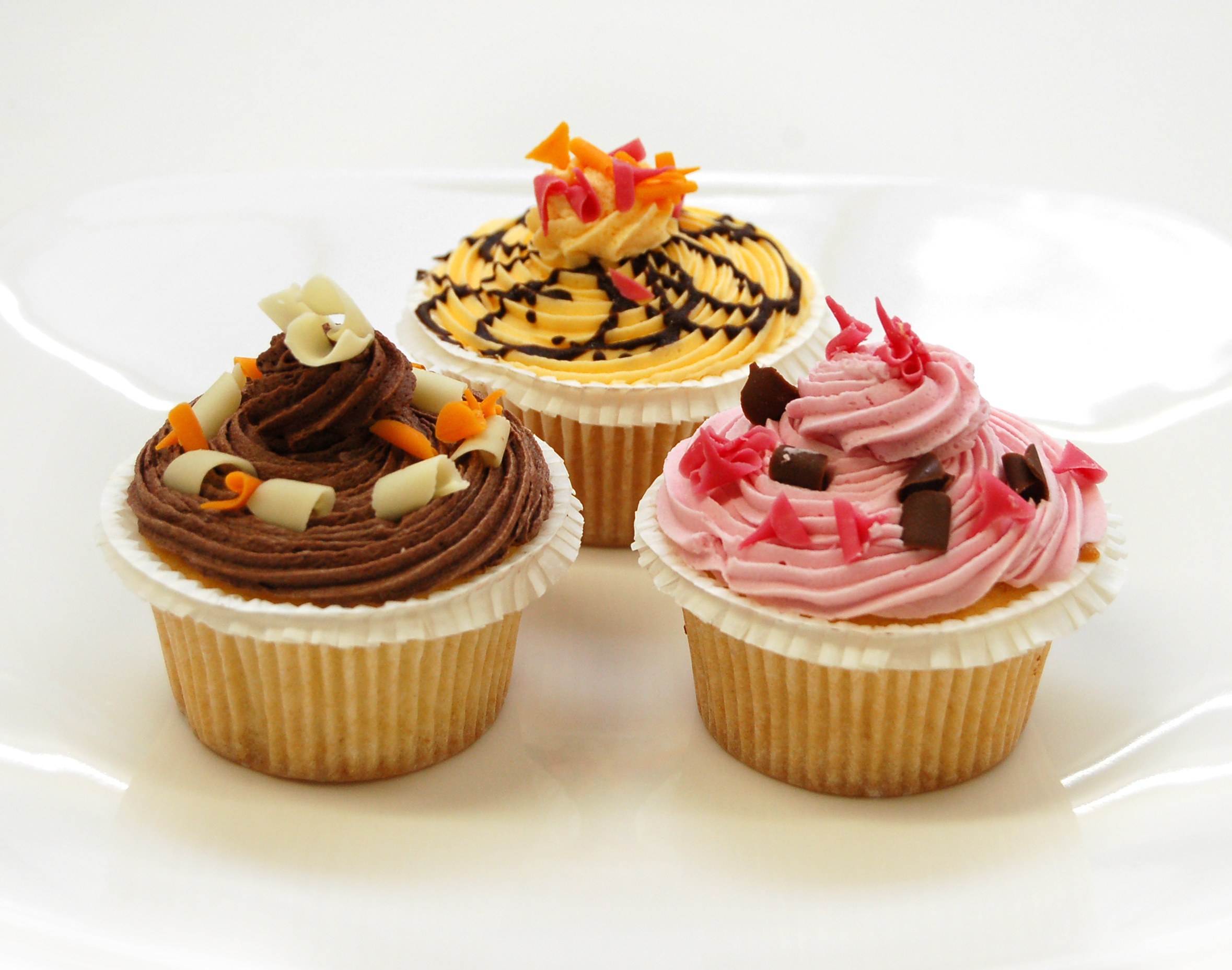 Three decorated cupcakes on a plate