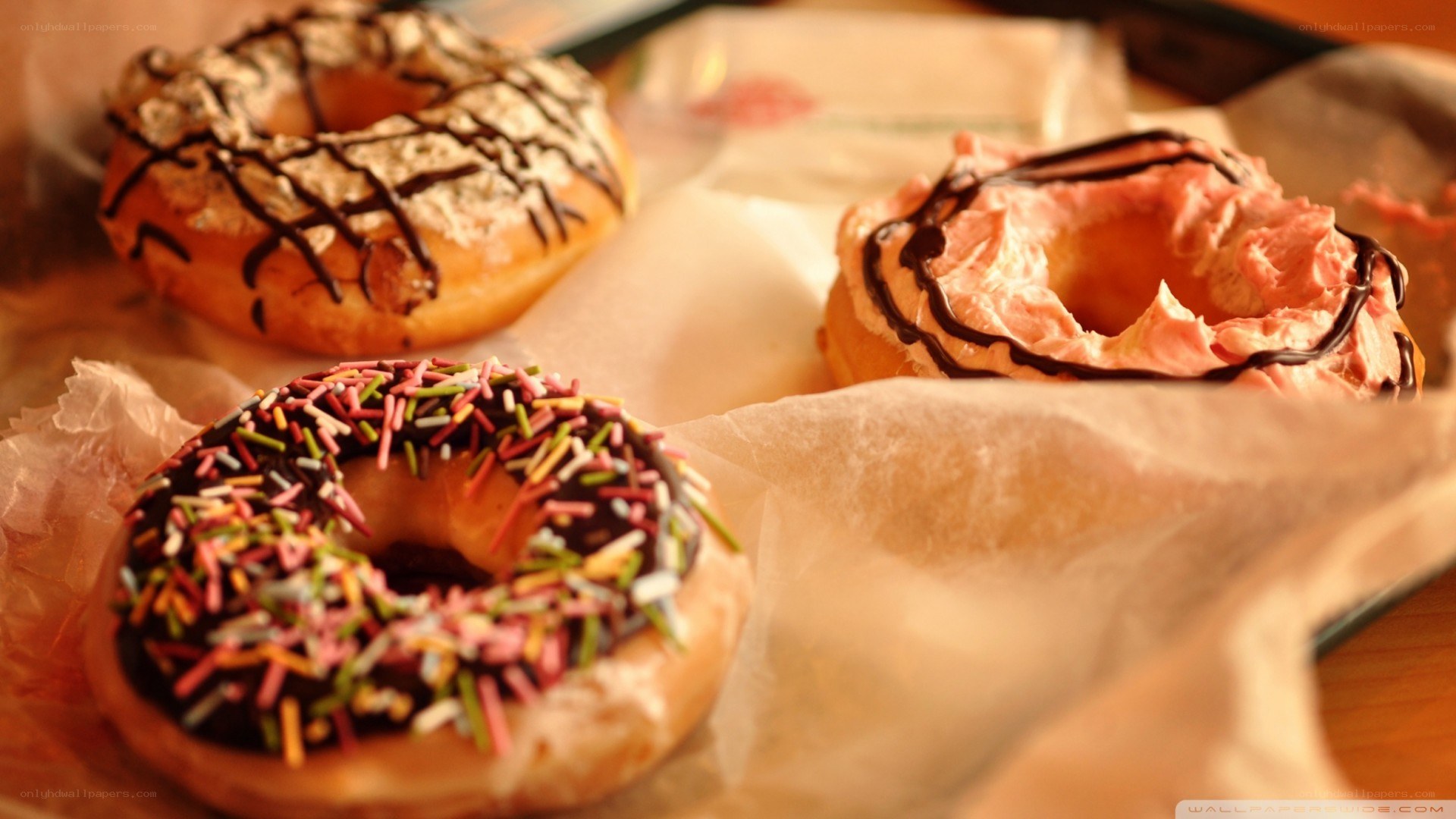 Three decorated donuts on parchment