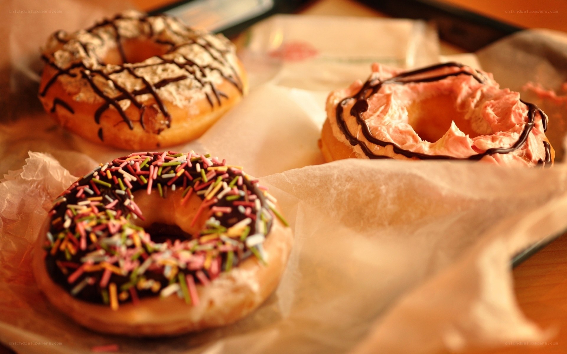 Three decorated donuts on parchment