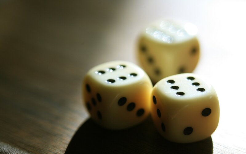 Three dice on a wooden surface