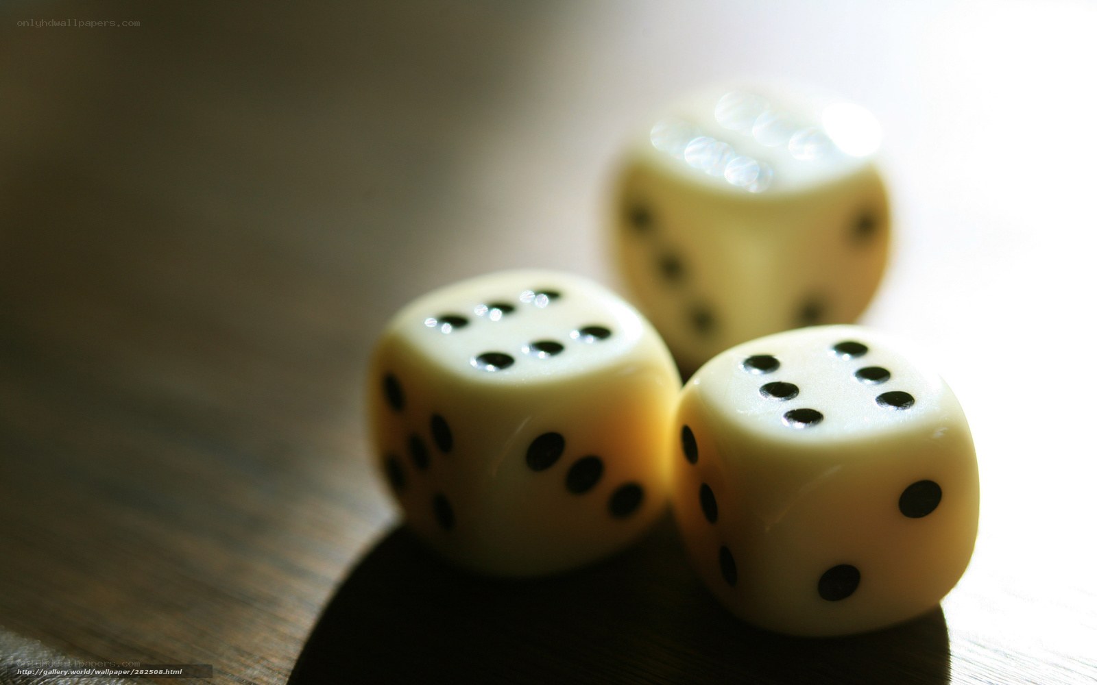 Three dice on a wooden surface