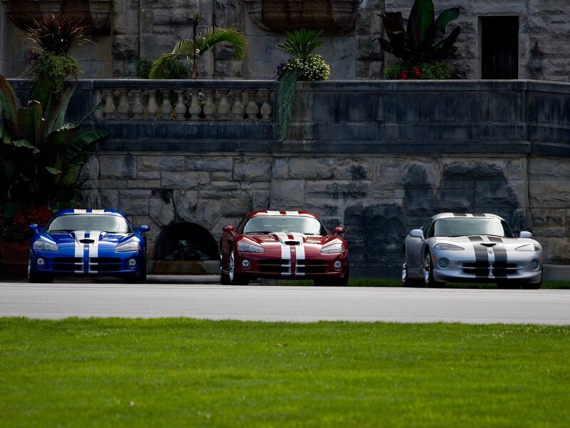 Three Dodge Vipers in front of a stone building