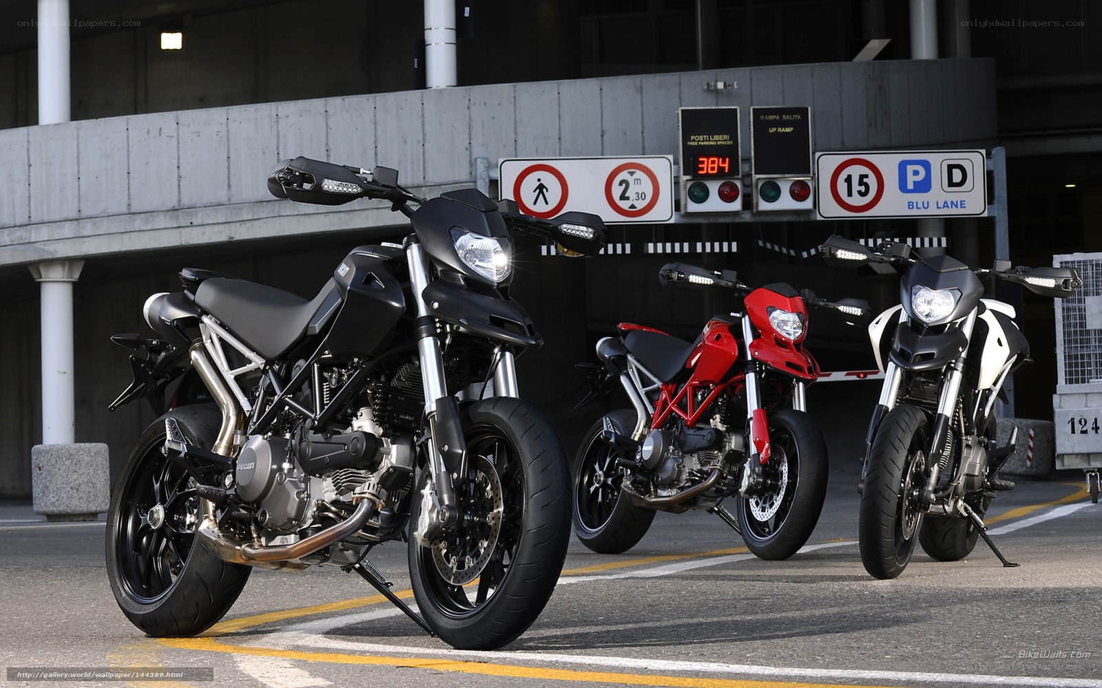 Three Ducati motorcycles in parking