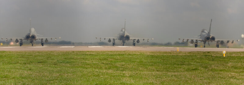 Three fighter jets on a runway