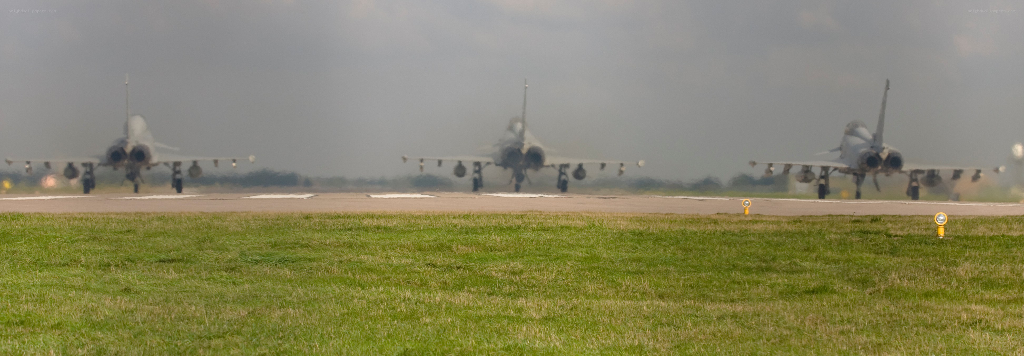 Three fighter jets on a runway