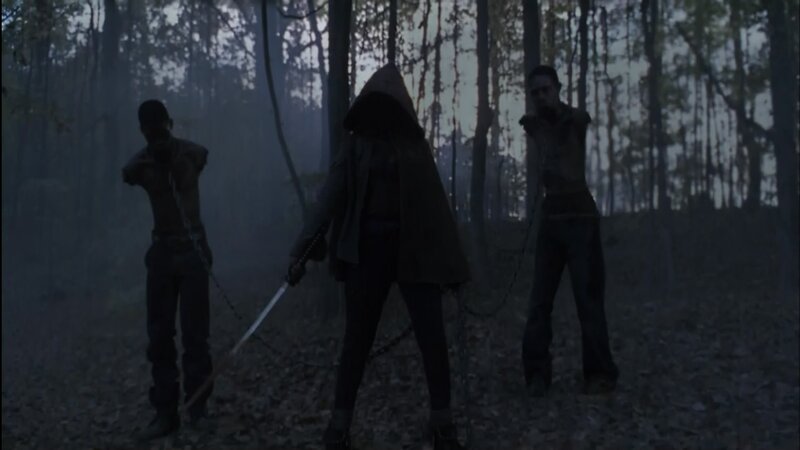 Three figures in a dark forest