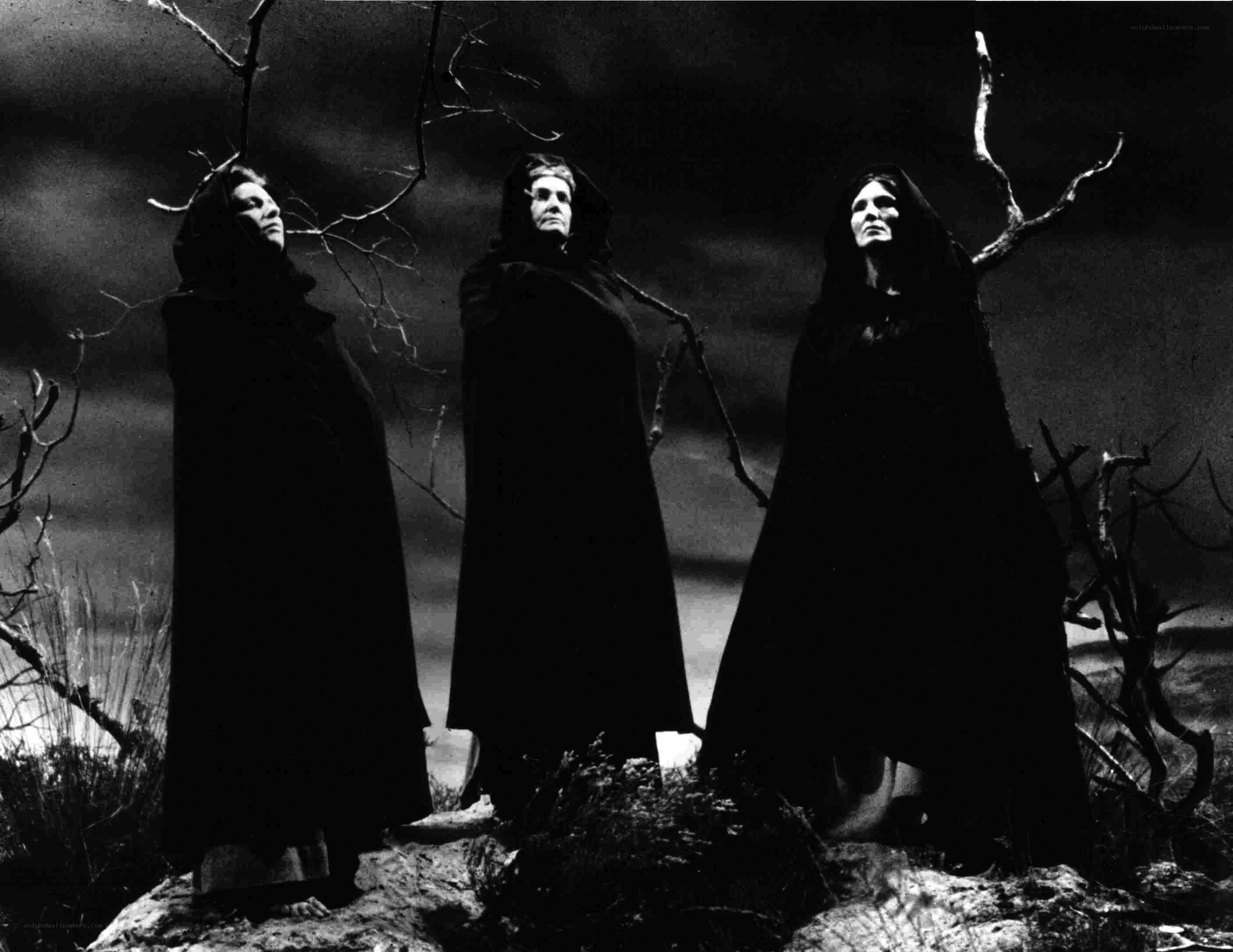 Three figures in cloaks on a hill