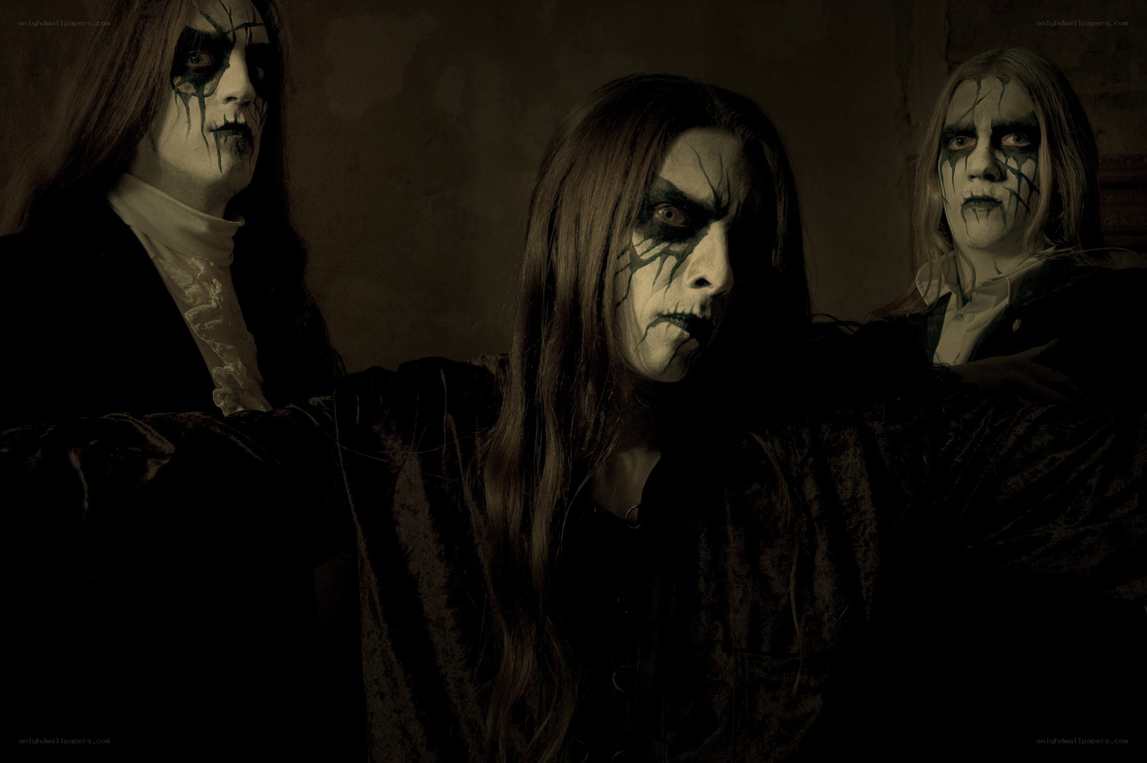 Three figures in dark makeup
