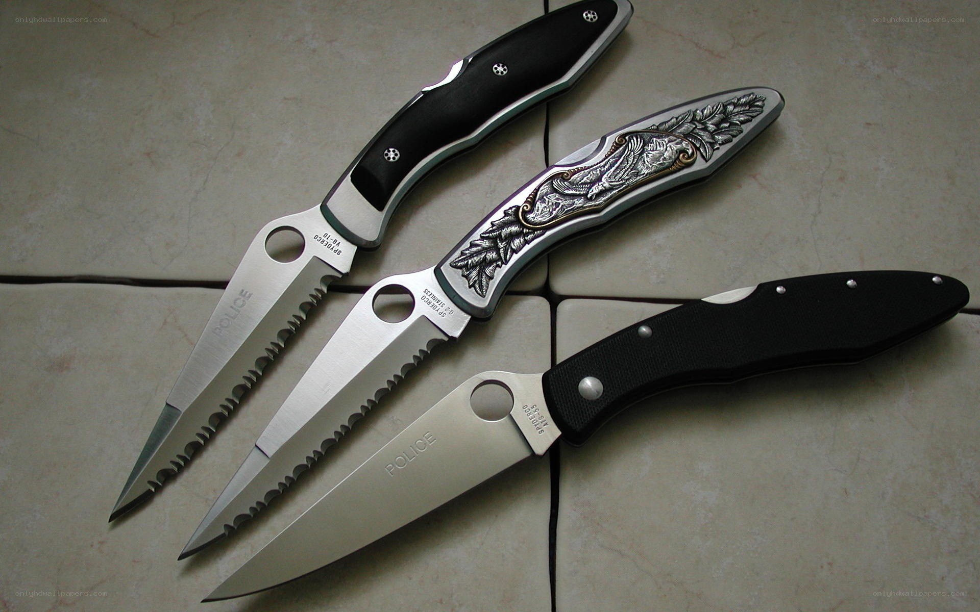 Three folding knives on tile