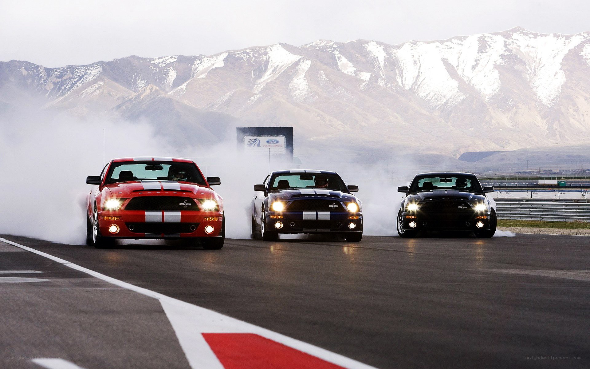Three Ford Mustangs on a racetrack