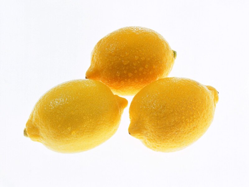 Three fresh lemons on white