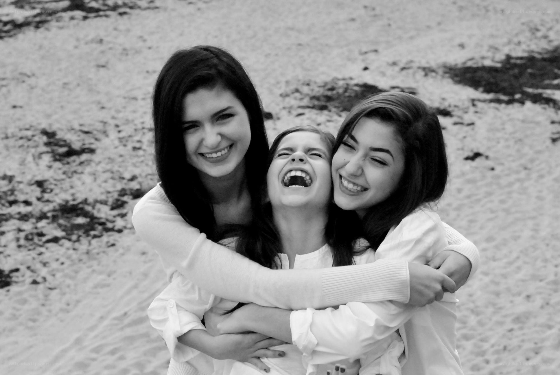 Three friends hugging on the beach