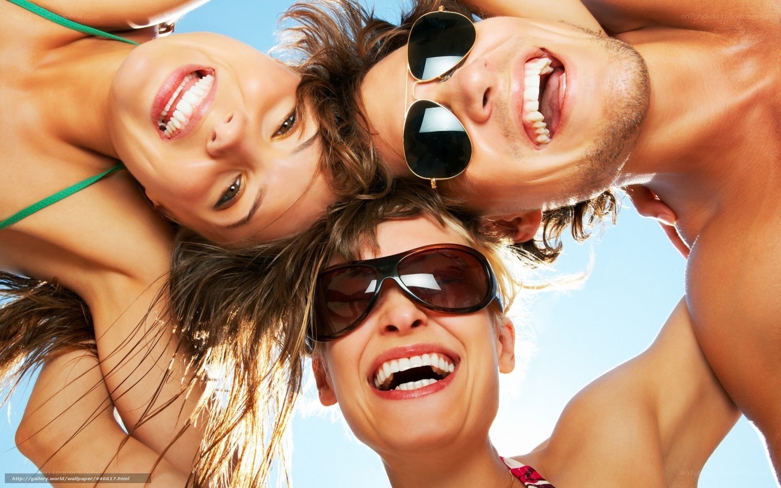 Three friends laughing at the beach