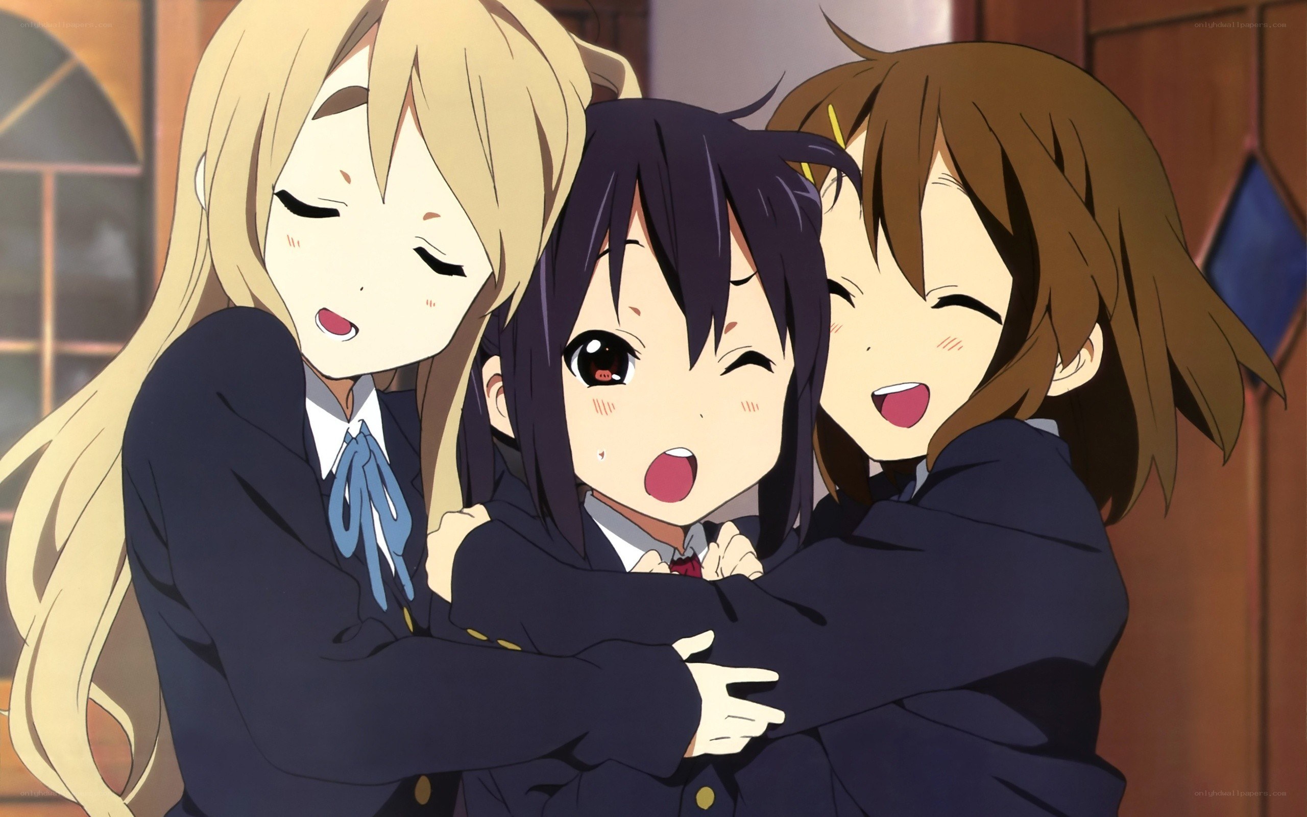 Three girls hugging in school uniforms