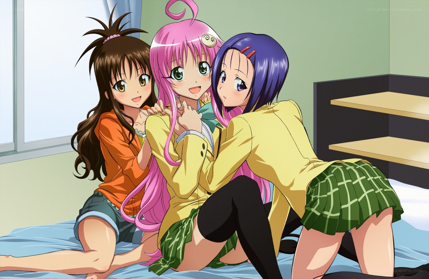 three girls hugging on a bed