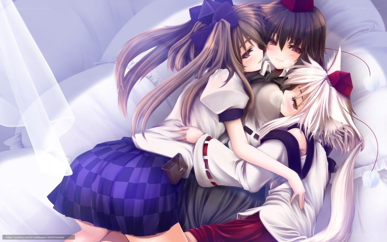 Three girls hugging on a bed