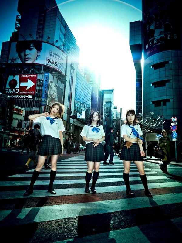 Three girls in school uniforms on a city street