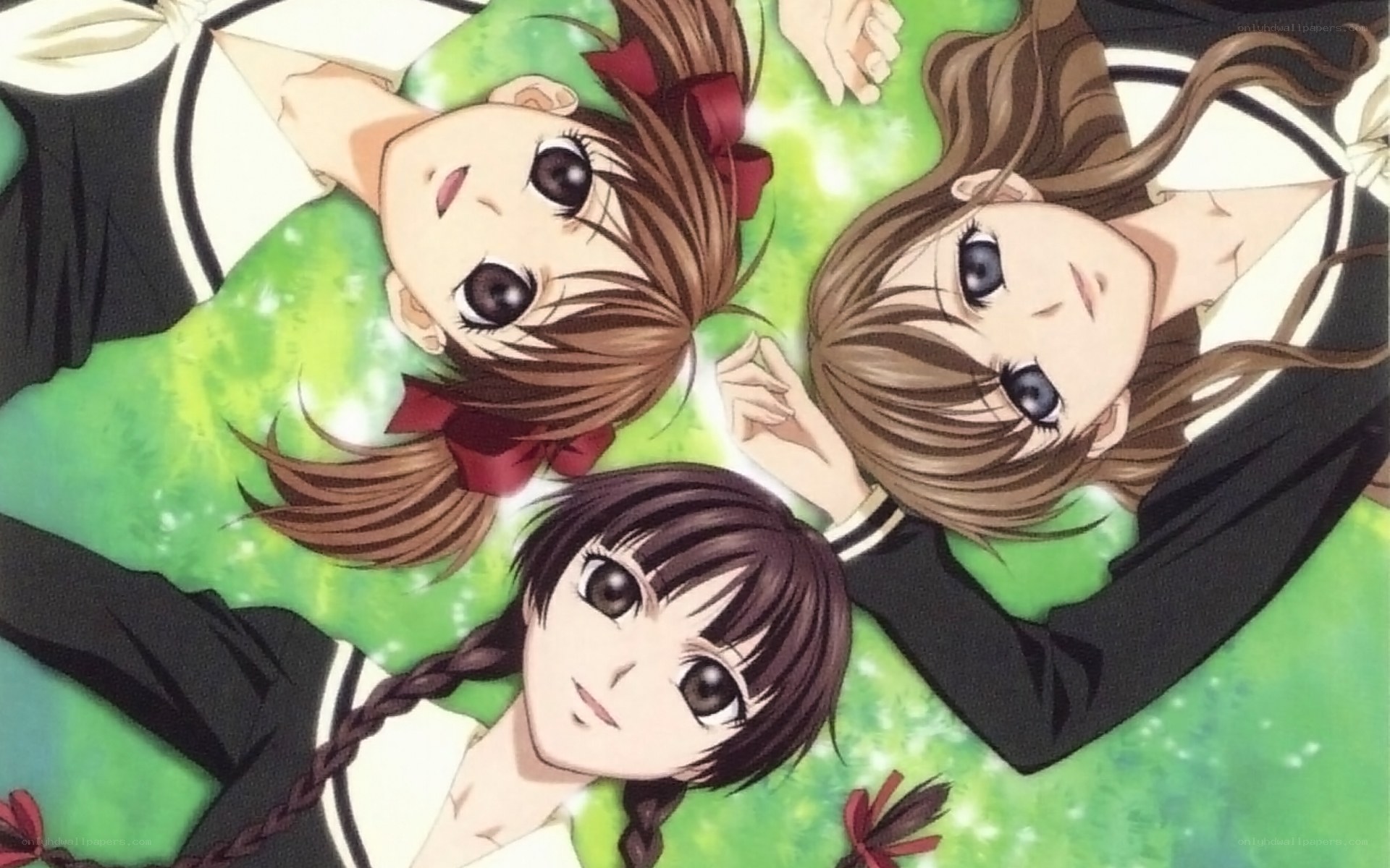 three girls lying on grass